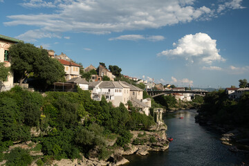 Obraz premium Wide angle landscape capturing the flowing Neretva river cutting through the deep rocky canyon below the historic town of Mostar, Bosnia.