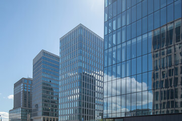 Fototapeta premium Glass skyscrapers with reflective windows against a clear blue sky