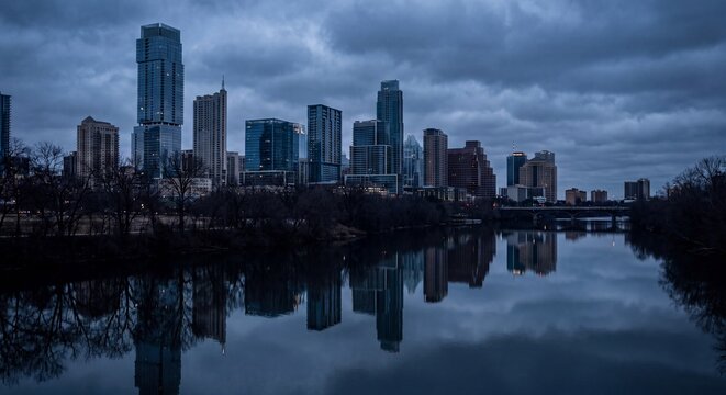 Moody blue hour view of the downtown Austin Texas city skyline reflecting on the calm waters of Lady Bird Lake