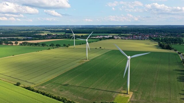 Windmill in a rural area. Offshore wind park. Wind turbines farm. Alternative renewable energy generation. Green energy concept. Organic harvest in farm field. Agricultural harvest