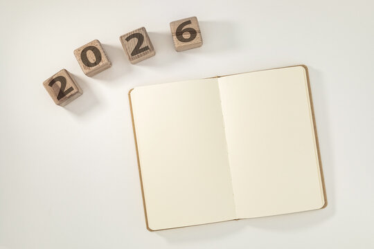 2026 Year Planning Concept with Blank Open Notebook and Wooden Cubes