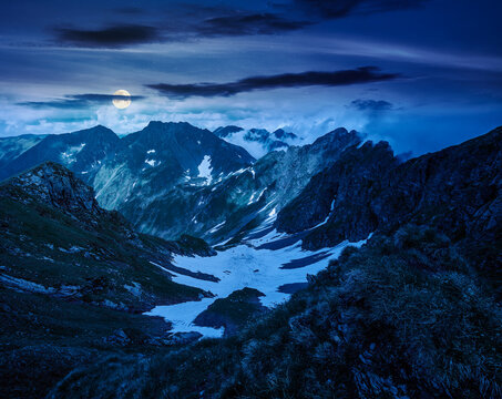 romania mountain landscape in summer at night. full moon over travel background of alpine scenery in fagaras mountain ridge. european summer outdoor adventures. mysterious fantasy
