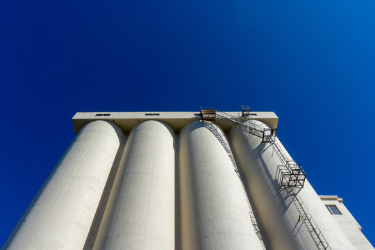 Grain silos storing agricultural products under blue sky