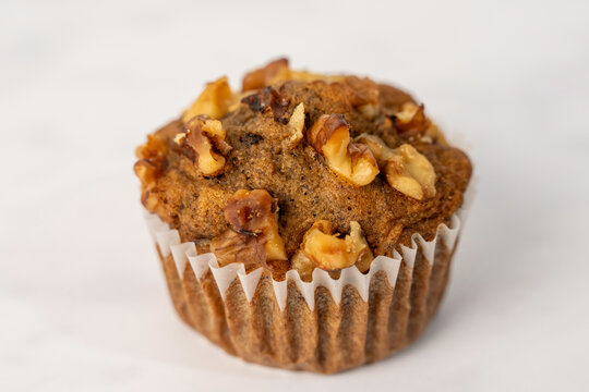 Banana muffins in paper liners sprinkled with walnuts 