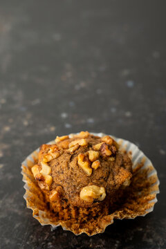 Banana muffins in paper liners sprinkled with walnuts 