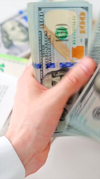 Male hands counting US Dollar bills, close-up