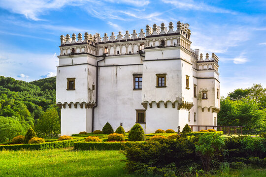 Scenic view of the renaissance fortified manor house in Szymbark surrounded by green foliage under a pastel twilight sky, Lesser Poland.