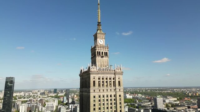 Aerial view of Warsaw&rsquo;s Palace of Culture and Science rising above the city, with clear blue sky, urban roads and iconic Polish capital architecture.