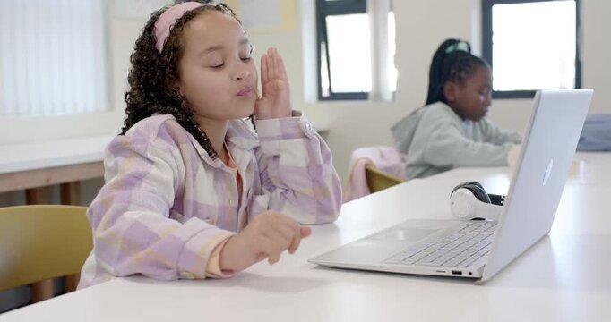 African American girls in class girl wearing band leaning using laptop drifting asleep from fatigue