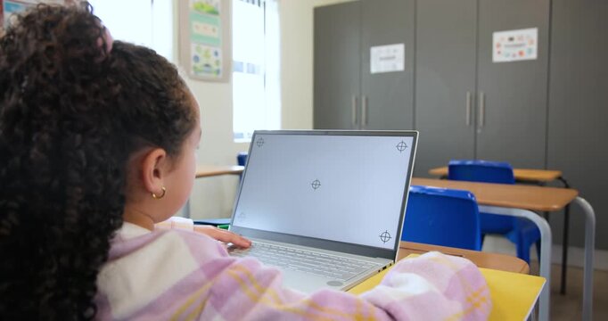 African American child leaning to laptop at school desk, typing, reacting to markers, copy space