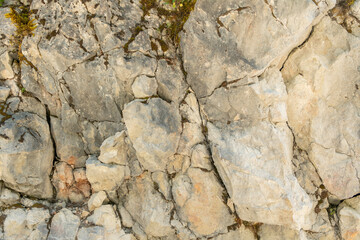 Fototapeta premium Imst, Tyrol, Austria. Natural limestone rock wall texture with weathered cracks and geological patterns
