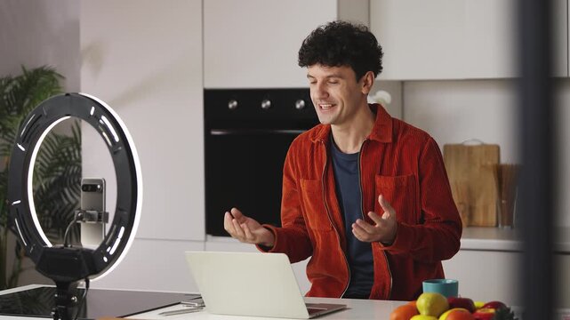 Smiling man blogger in his 30s recording lifestyle vlog on cellphone, influencer