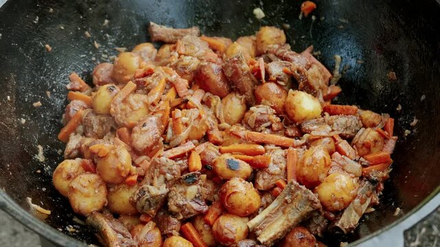 Cooking food in a wok stirring and cooking ingredients, in kitchen environment, and active and warm mood.