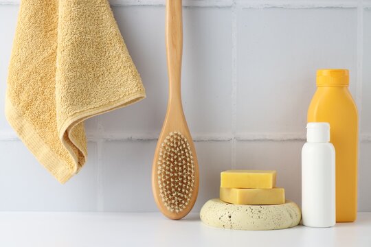Different bath products on white table near tiled wall