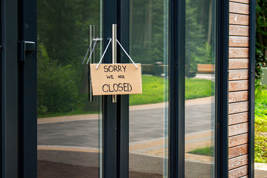 Closed notice on cafe entrance. Small business failure and financial pressure. Local business collapses under debt. Abandoned business concept
