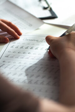 Calligraphy training. Woman writing accurately in copybook with pen. Adult practicing cursive in propisi notebook. Global shift to analog habits