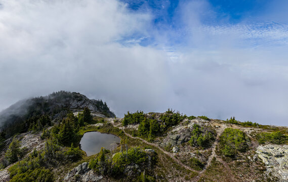 Foggy Mountain Peak Over Alpine Tarn With Evergreen Trees Near Hope, British Columbia, Canada