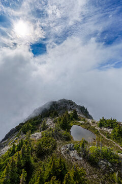 Misty Alpine Mountain Summit With Reflective Tarn and Dramatic Clouds Near Hope, British Columbia, Canada