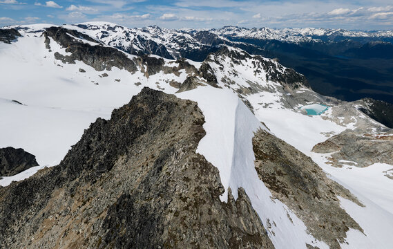 Aerial View of Snow-Covered Mountain Ridge and Turquoise Alpine Lake in British Columbia, Canada