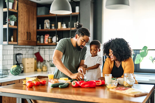 Portrait of mother, father and son preparing a meal in the kitchen at home