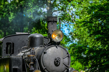 Close side view of black steam locomotive headlamp outdoors. © Trygve