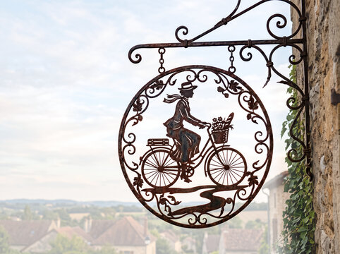 wrought iron cut out hanging sign illustration of elegant woman riding bicycle