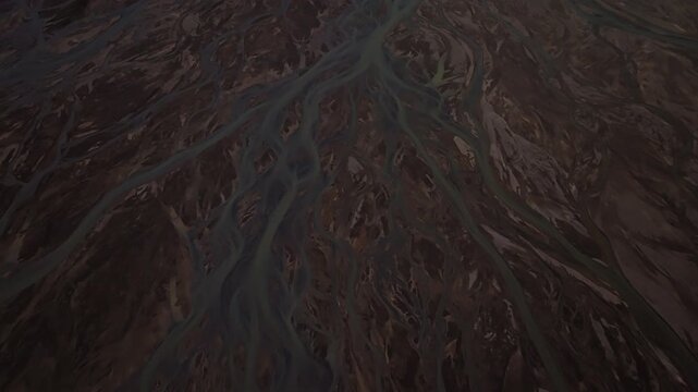 Cinematic aerial flight above braided glacial rivers in Iceland&rsquo;s remote Highlands revealing intricate river channels volcanic terrain and colorful landscapes near the Rainbow Mountains.