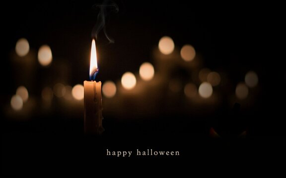 Happy Halloween text against blury spooky candles light 