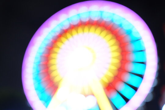 Soft focus bokeh of colorful lights on a ferris wheel at night