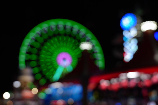 Blurry, colorful lights of a night carnival create a festive, dreamlike atmosphere
