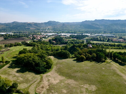 Aerial view of green fields and rolling hills in Italy for country tourism background