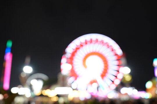 Soft focus bokeh of a ferris wheel at the county fair at night