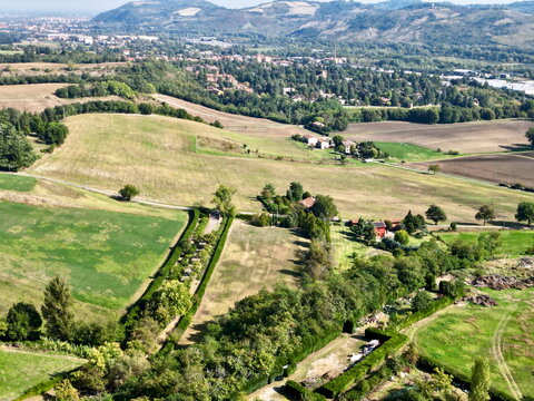Aerial view of country driveway and green fields in Italy for real estate background