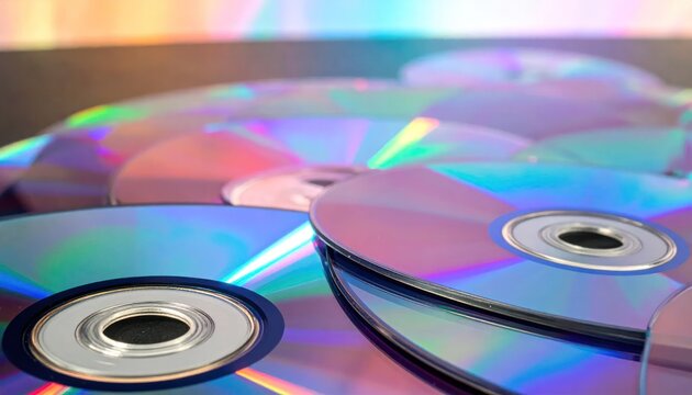 Stack of iridescent compact discs with rainbow reflections.