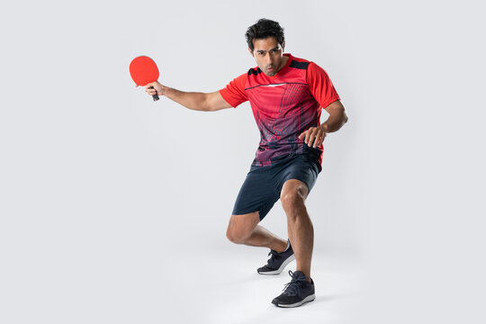 Man playing table tennis with intense focus and athletic stance