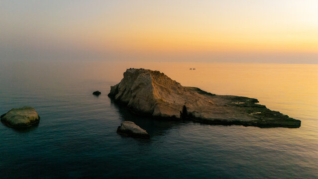 A beautiful sunrise over the dramatic shoreline of Mandrakia on the Greek island Milos. Calm water and vibrant colors. 