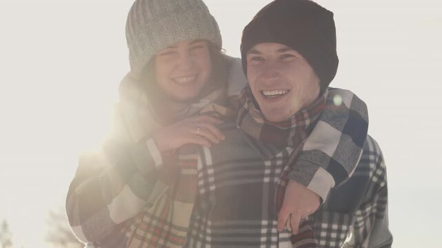 A cheerful couple poses outside in winter attire, radiating happiness and warmth. Their genuine smiles and close embrace capture the spirit of love and togetherness in the cold season