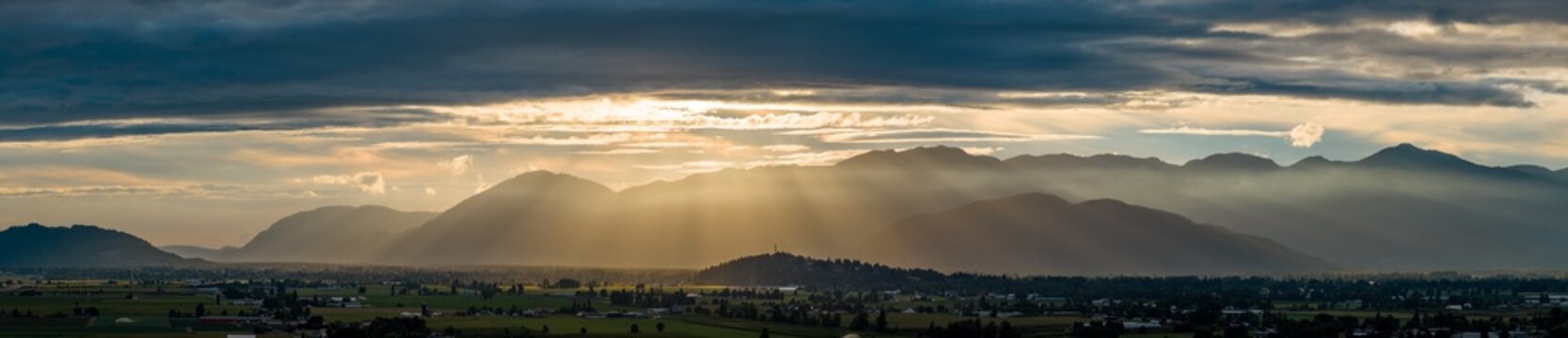 Golden Sun Rays Over Chilliwack Valley Mountains at Sunset, Farmland and Misty Layers in British Columbia