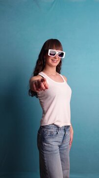 Stylish young woman pointing finger at camera