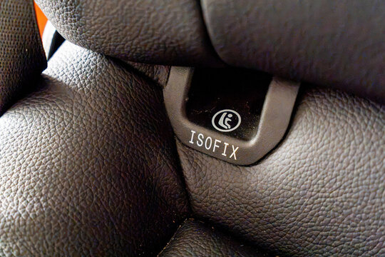 Close-up of an ISOFIX label on a leather car seat. Concept of child safety, secure car seat installation, and modern vehicle technology