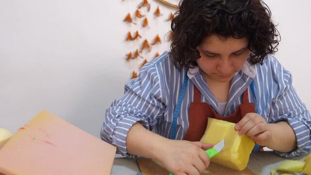 Artisan creating puppet head with utility knife
