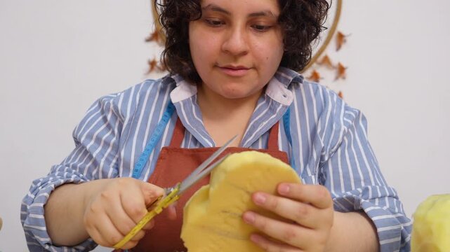 Focused female artisan crafting a puppet in a workshop