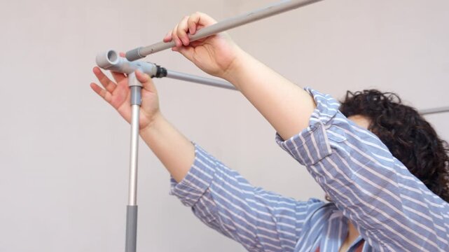 Artisan woman assembling pipe frame for puppet theater