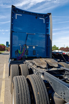 The rear of a blue semi truck with its 5th wheel and no trailer