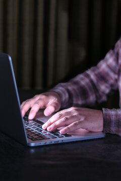 Detail shot of male hands working on laptop late at night