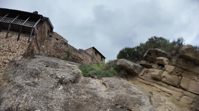 David Gareji complex showing an ancient rock-hewn Orthodox monastery in Georgia, featuring a weathered wooden door with a cross and rough stone walls carved into the mountain during the Middle Ages