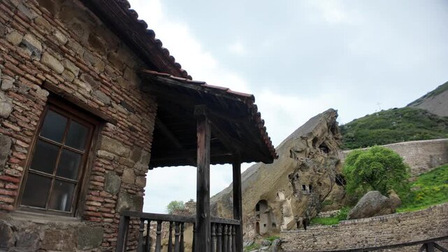 David Gareji 6th-century rock-hewn cave monastery complex in Georgia featuring ancient stone walls, wooden beams, and a viewing balcony overlooking historical religious architecture