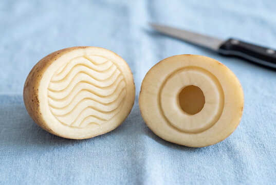 Raw potato halves carved with wavy lines and circles for making craft stamps