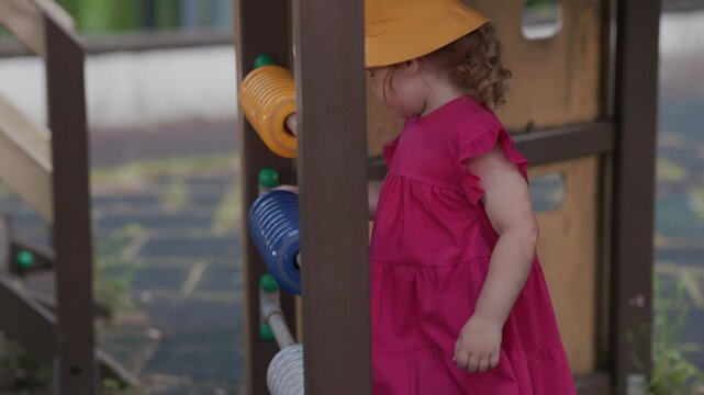 Little girl playing with colorful abacus on playground. Child learning basic counting and logic with educational toy. Preschool education and fun outdoor activity for young kid.
