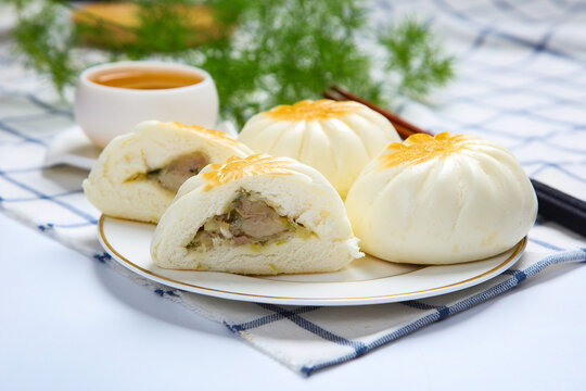 Three pan fried buns on blue and white porcelain plate tea chopsticks dark cloth
